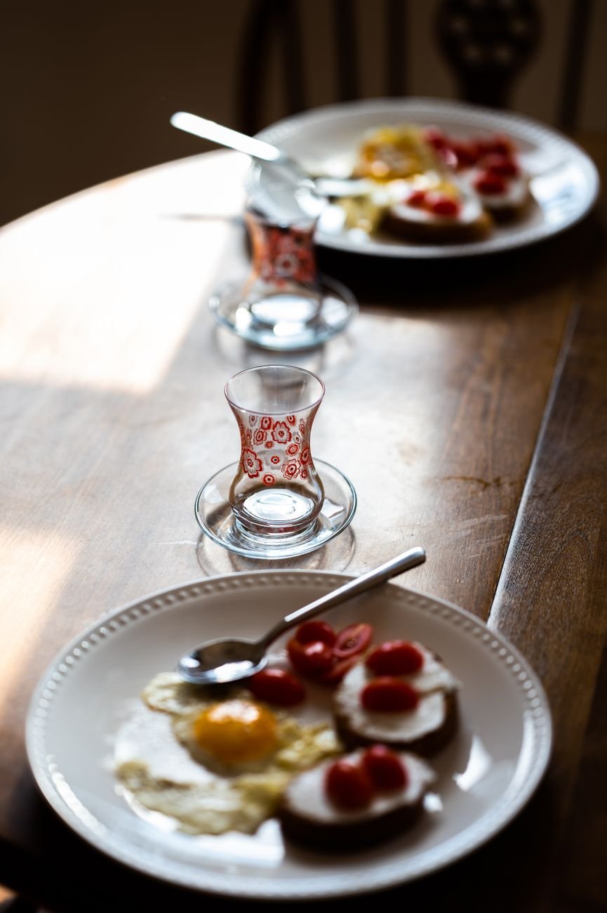 Inviting breakfast of fried eggs and tea on a wooden table in natural light.